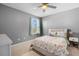 Bright bedroom featuring soft gray walls, carpet floors, and a queen-sized bed with floral bedding at 303 Red Kite Dr, Groveland, FL 34736