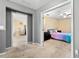Neutral hallway showcasing bedroom with ceiling fan, pastel bedding, and carpet flooring at 303 Red Kite Dr, Groveland, FL 34736