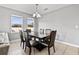 Bright dining room with two windows, a chandelier and a modern dark wood table and chairs at 303 Red Kite Dr, Groveland, FL 34736