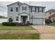 Charming two story home featuring blue exterior, well manicured lawn, and two car garage at 303 Red Kite Dr, Groveland, FL 34736