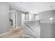 Spacious second floor hallway featuring carpet floors, gray walls, white doors, and painted handrail at 303 Red Kite Dr, Groveland, FL 34736