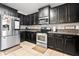 This kitchen features stainless steel appliances, tile floors, and black cabinets at 303 Red Kite Dr, Groveland, FL 34736