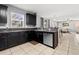 This kitchen features stainless steel appliances, tile floors, and black cabinets at 303 Red Kite Dr, Groveland, FL 34736