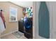 Well-organized laundry room with modern washer and dryer, storage shelves, and natural light from a window at 303 Red Kite Dr, Groveland, FL 34736