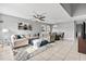 Spacious living room and dining room area with tile flooring, modern lighting, and a comfortable sectional at 303 Red Kite Dr, Groveland, FL 34736