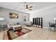 Comfortable living room with neutral-toned sofa, ottoman, rug, and fan; bookshelf provides ample storage at 303 Red Kite Dr, Groveland, FL 34736