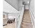 Bright staircase features white railings and carpeted stairs, leading to the upper level of the home at 303 Red Kite Dr, Groveland, FL 34736