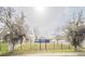 A backyard with a lush green lawn, framed by a black fence, trees, and a bright blue house in the background at 3339 Landing Vw, Tavares, FL 32778