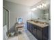 Bright bathroom featuring a granite vanity, separate dressing table, and glass-enclosed shower at 3339 Landing Vw, Tavares, FL 32778