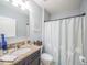 Comfortable bathroom with granite vanity, framed artwork, and a shower with curtain at 3339 Landing Vw, Tavares, FL 32778