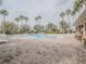 A spacious community pool surrounded by palm trees, lounge chairs, and a well-maintained brick patio area at 3339 Landing Vw, Tavares, FL 32778