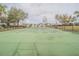 A well-maintained tennis court featuring a green playing surface, crisp white lines, and a surrounding black fence at 3339 Landing Vw, Tavares, FL 32778