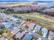 An aerial view of homes on a quiet street next to a golf course and lake at 33409 Pennbrooke Pkwy, Leesburg, FL 34748