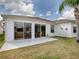 A home's bright back patio features two sliding glass doors and a well-maintained backyard at 33409 Pennbrooke Pkwy, Leesburg, FL 34748