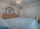Bright bedroom features a queen-size bed with blue bedding, large dresser, and double door closet at 33409 Pennbrooke Pkwy, Leesburg, FL 34748