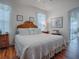 Inviting bedroom with a queen bed, warm wood flooring, and soft, sheer curtains at 33409 Pennbrooke Pkwy, Leesburg, FL 34748