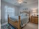 Bedroom features a queen-size bed with blue bedding, nightstand, and window with lace curtains at 33409 Pennbrooke Pkwy, Leesburg, FL 34748