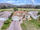Aerial view of a charming single-story house with a well-manicured lawn and a brick driveway at 33409 Pennbrooke Pkwy, Leesburg, FL 34748