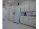 Bright kitchen features white cabinets, appliances, and tile flooring for a clean, classic look at 33409 Pennbrooke Pkwy, Leesburg, FL 34748
