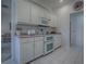Well-lit kitchen offers an oven, microwave, and white cabinetry for a functional cooking space at 33409 Pennbrooke Pkwy, Leesburg, FL 34748