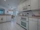 Functional kitchen with white appliances, tile flooring, and a view towards the dining area at 33409 Pennbrooke Pkwy, Leesburg, FL 34748