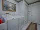 Laundry room features a washing machine and dryer next to white interior doors at 33409 Pennbrooke Pkwy, Leesburg, FL 34748