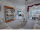 Spacious living room with display cabinet, glass table and open access to the kitchen and dining areas at 33409 Pennbrooke Pkwy, Leesburg, FL 34748