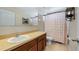 Functional bathroom with a tile floor, a mirror, a vanity and a shower with a patterned curtain for privacy at 412 Arbor Pointe Ave, Minneola, FL 34715
