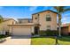 Two-story home with manicured lawn, two car garage and traditional architectural details at 412 Arbor Pointe Ave, Minneola, FL 34715
