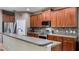Kitchen with a modern stainless steel range, wood cabinets, and stylish tiled backsplash at 412 Arbor Pointe Ave, Minneola, FL 34715