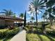 Sidewalk leads to a pool area with lush landscaping, palm trees and a building with the address number visible at 412 Arbor Pointe Ave, Minneola, FL 34715