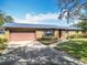 Charming brick home with a well-maintained lawn, paved driveway, and a covered front porch at 4918 County Road 114, Wildwood, FL 34785