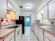 Efficient galley kitchen with white appliances, cabinets and access to the rest of the home at 4918 County Road 114, Wildwood, FL 34785