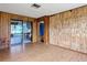 Inviting living area featuring unique wood paneled accent wall and a sliding glass door to the backyard at 4918 County Road 114, Wildwood, FL 34785