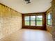 Bright living area featuring unique wood paneled accent wall and a large window to the backyard at 4918 County Road 114, Wildwood, FL 34785