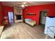 Inviting living room with hardwood-style floors, stone fireplace and bright red walls at 5 Magnolia Ln, Yalaha, FL 34797