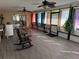 Inviting sun room with tile flooring, ceiling fans, large windows, and bright curtains create a relaxing space at 5 Magnolia Ln, Yalaha, FL 34797