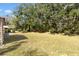 View of the large backyard with mature trees, showcasing outdoor space at 520 Saint Andrews Blvd, The Villages, FL 32159