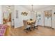 Bright dining room with modern chandelier, light wood floors, and an adjacent serving area at 520 Saint Andrews Blvd, The Villages, FL 32159