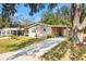 Beautiful house with a manicured lawn, covered parking, and a charming walkway at 520 Saint Andrews Blvd, The Villages, FL 32159
