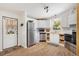 Bright kitchen featuring stainless steel appliances, white cabinetry, and a stylish exterior door at 520 Saint Andrews Blvd, The Villages, FL 32159