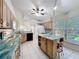 Sunlit kitchen featuring wooden cabinets, an island with seating, and large windows offering outdoor views at 600 Arlington Ct, Eustis, FL 32726