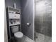 Bathroom featuring tiled shower, toilet, storage cabinet, and modern finishes at 600 Urick St, Fruitland Park, FL 34731