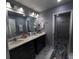A bathroom with a dual sink vanity, large mirror, and walk-in glass shower at 600 Urick St, Fruitland Park, FL 34731