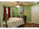 Well-lit bedroom with a ceiling fan, a bed and a large window dressed with red curtains at 600 Urick St, Fruitland Park, FL 34731