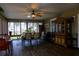 A screened sunroom with a ceiling fan, dining table, and a large cabinet at 600 Urick St, Fruitland Park, FL 34731