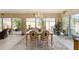 Bright dining room with large windows, elegant chandelier, and a view of the lush outdoor landscaping at 6025 Dijulio Ter, The Villages, FL 32163