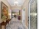 Elegant foyer with decorative rug leading to an expansive living space and filled with natural light at 6025 Dijulio Ter, The Villages, FL 32163