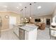 Open-concept kitchen featuring an island with seating, stainless steel appliances, and seamless flow to the living area at 6025 Dijulio Ter, The Villages, FL 32163