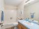 Well-lit bathroom with blue countertops, tiled floors, and a combination tub and shower at 606 San Maria Street, Lady Lake, FL 32159